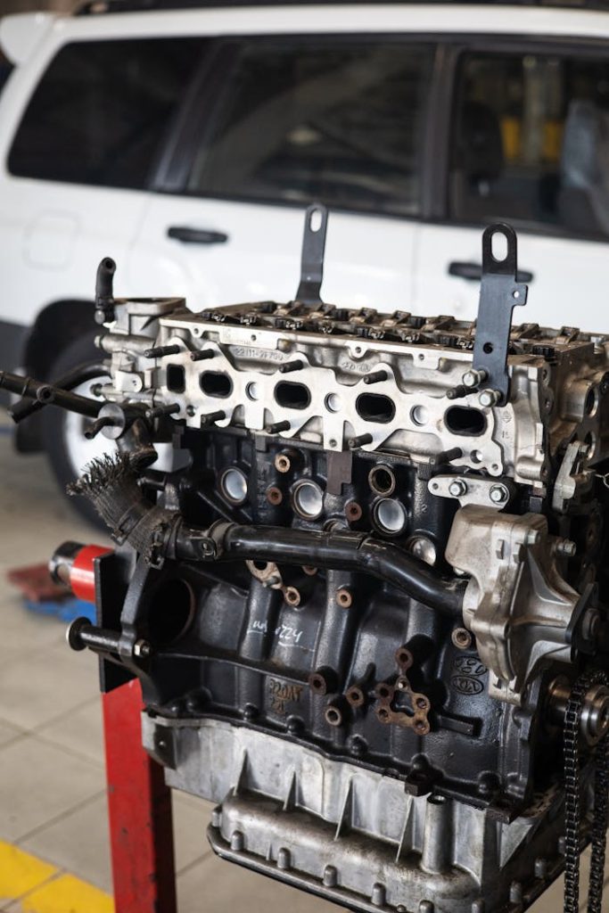 a-car-engine-at-an-auto-repair-shop-8985968 Detailed view of a car engine in an auto repair shop with a blurred vehicle in the background.